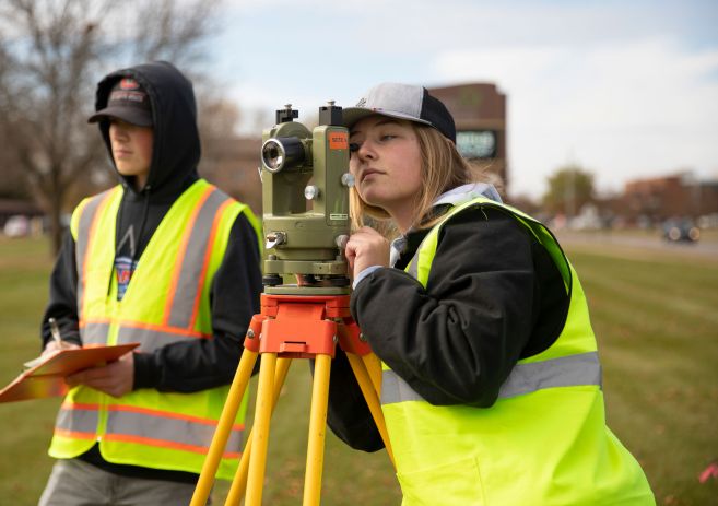 Two Land Survey students using equipment