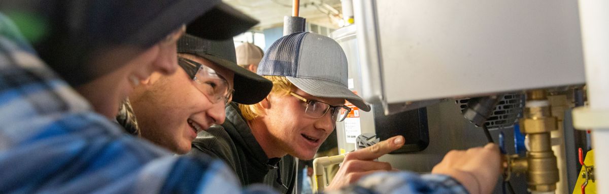 Plumbing students at water heater