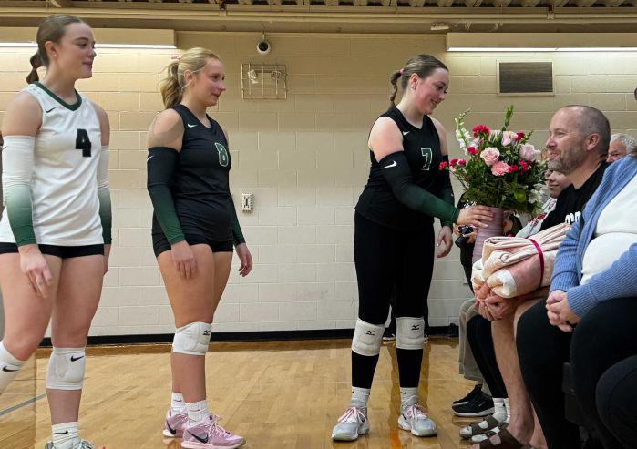 Makenzie handing family members a bouquet at the game