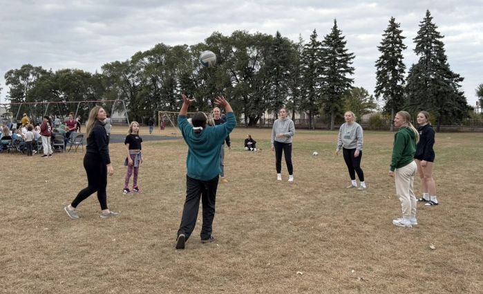 Volleyball team outdoors setting the ball in a circle