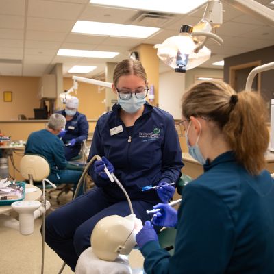 a group of dental assisting students in lab, practicing techniques