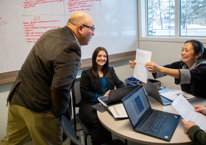 Business students talking with instructor