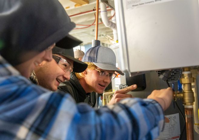 Plumbing students at water heater