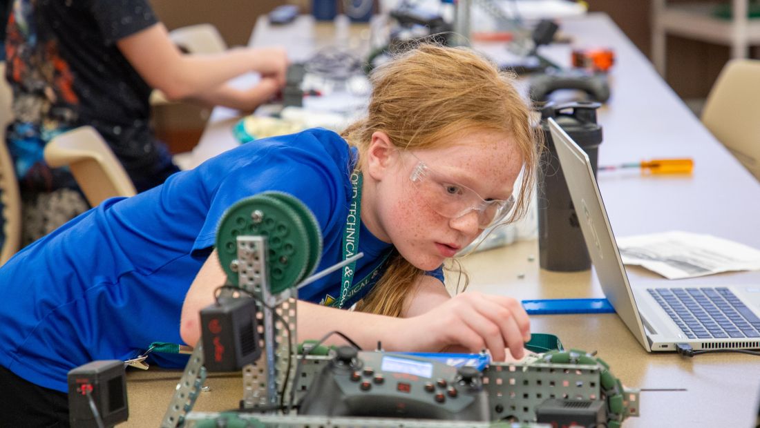 student focused on repairing robot