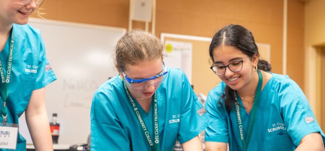 Students working on a dissection, specimen out of frame