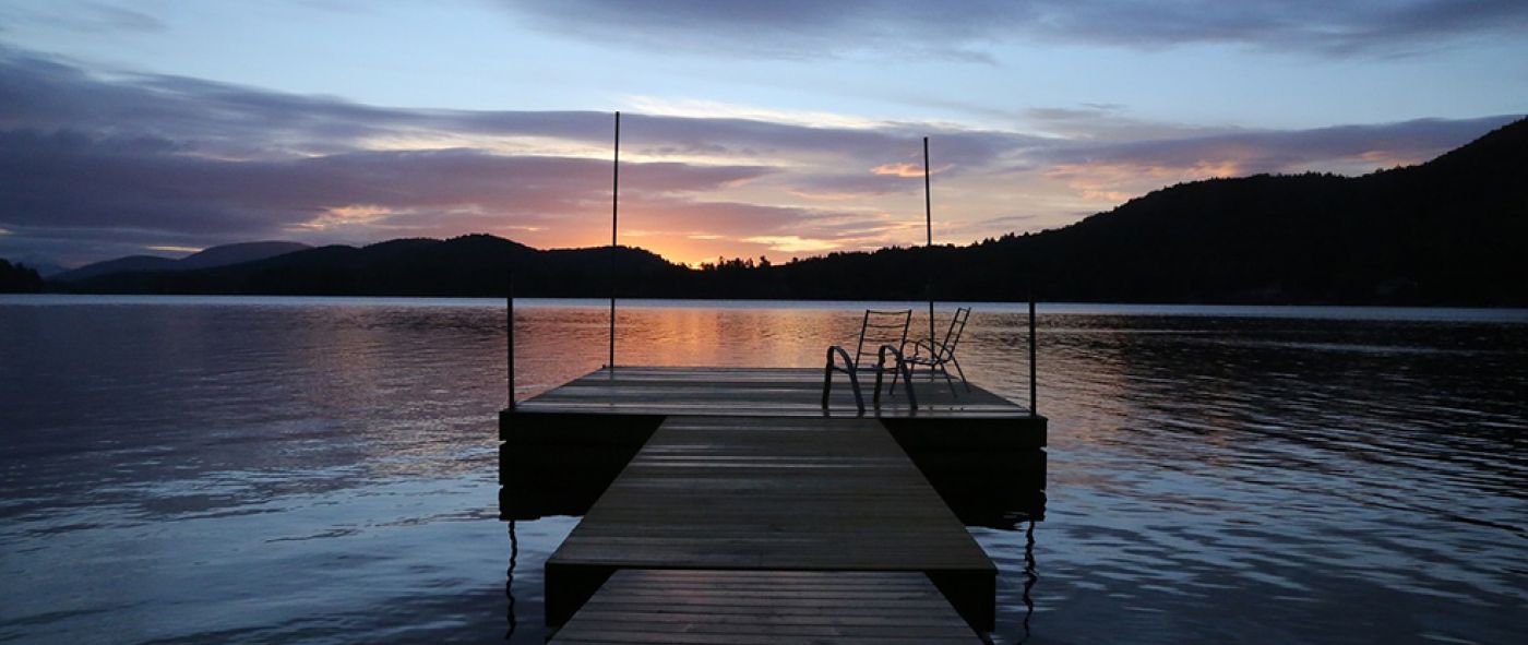 view of dock on lake at sunset