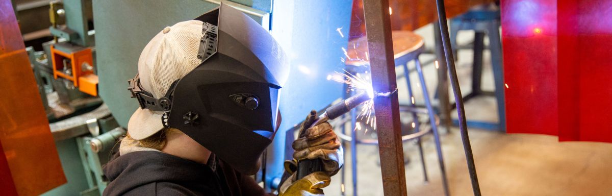 Welding student with sparks