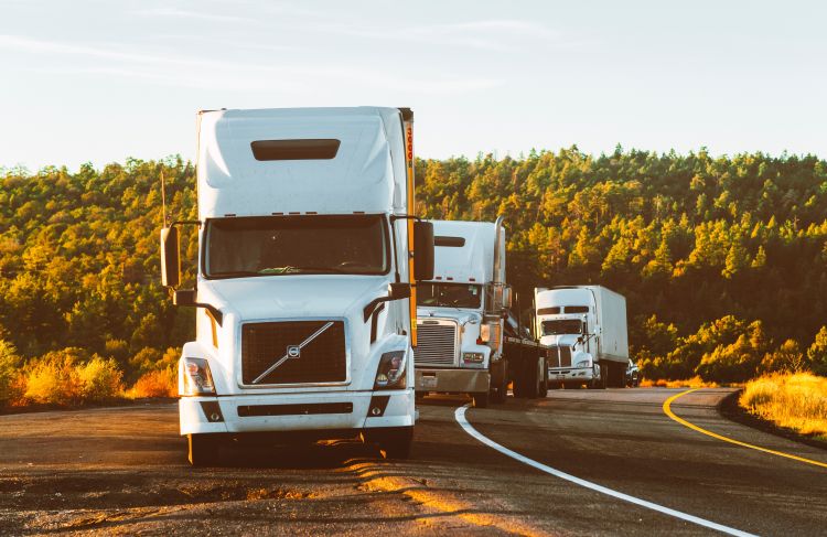 semi truck and trailers lineup on rural road