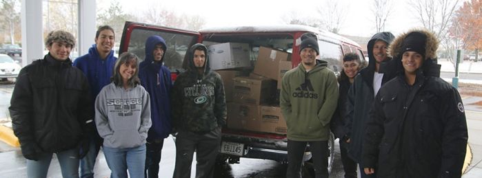 Students in front of van loaded with boxed donations