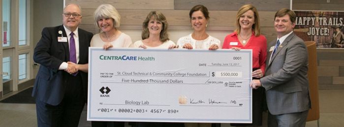 Administration holding large check for CentraCare donation