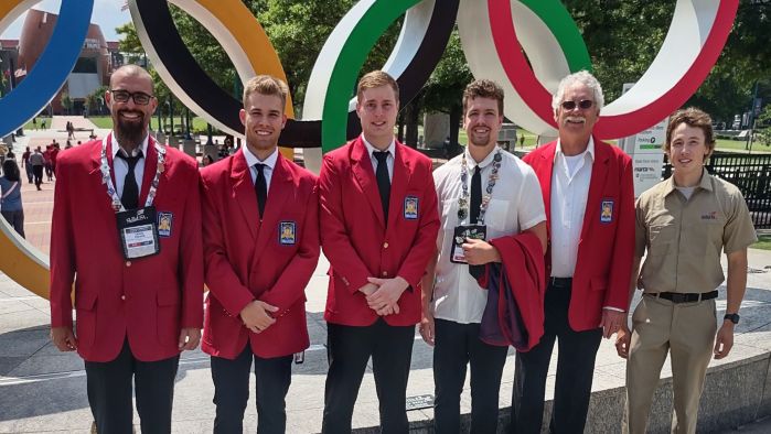 SkillsUSA National Competition attendees smiling in front of olympic rings