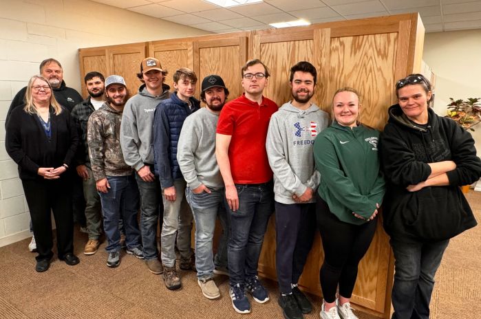 Line of Carpentry students in front of closet