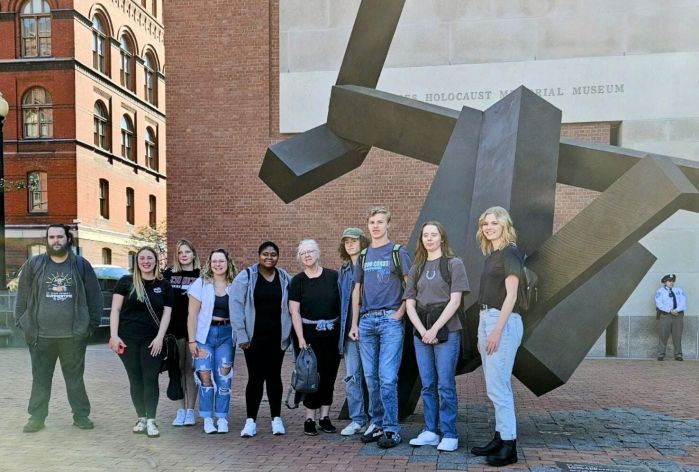 students standing in front of sculpture outside museum