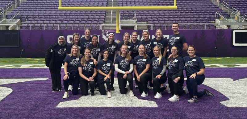 Dental hygiene students in three rows on the vikings field