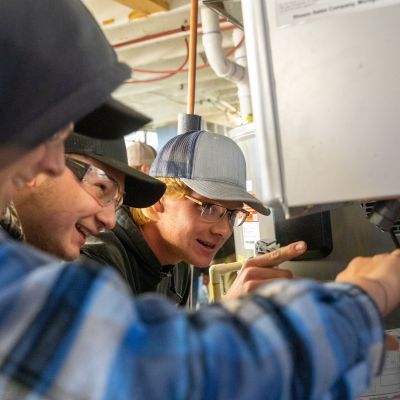 Plumbing students at water heater