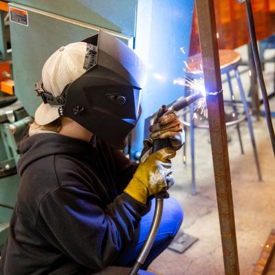 Welding student with sparks