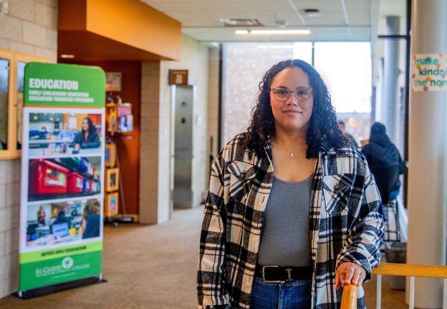 Tatiana in front of a window along with education banner