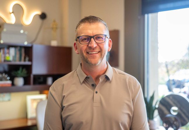 Trevor Akervik smiling in his office