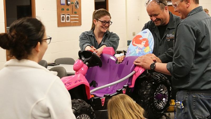 Energy and Electronics students holding modified pink toy car