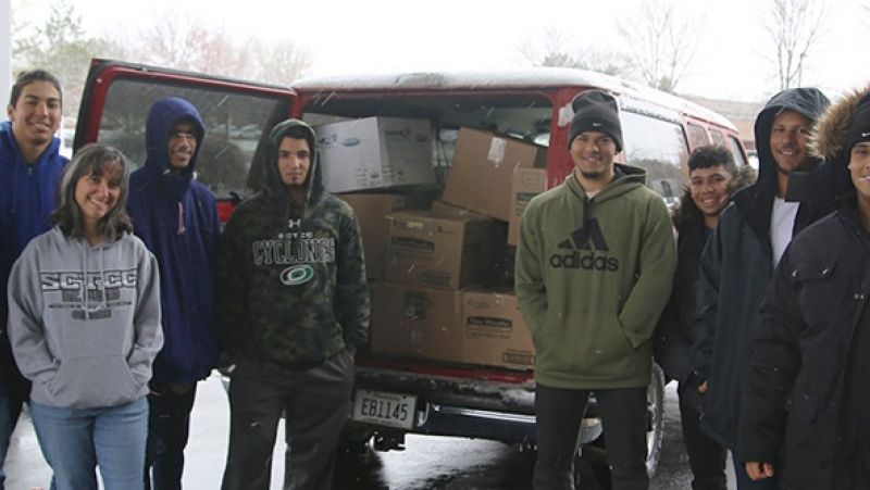 Students in front of van loaded with boxed donations