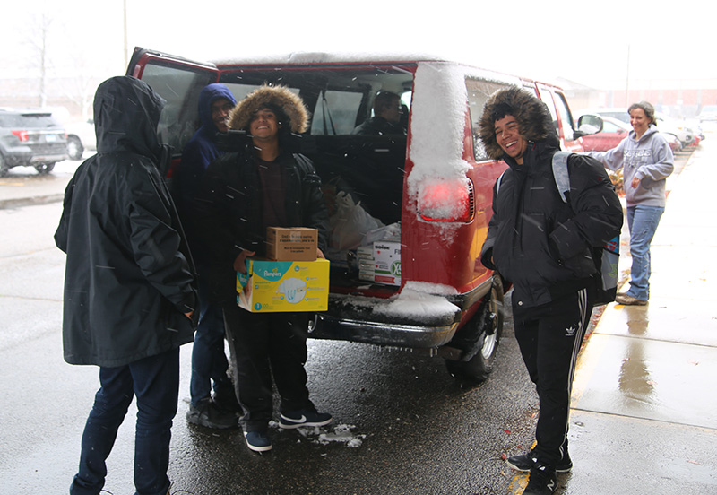 Students working together to pack donations into van